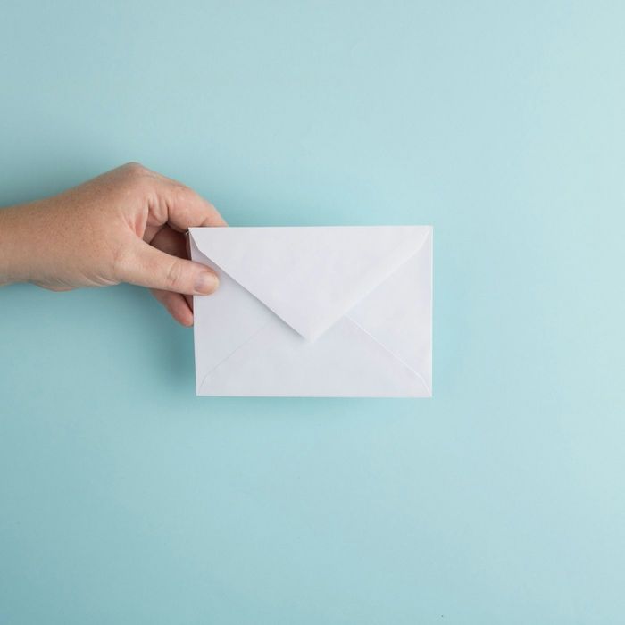 Mão segurando um envelope branco